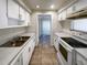 Efficient kitchen with white cabinets, laminate counters, and an opening to a dining area or a living space at 1819 E Humphrey St, Tampa, FL 33604