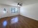 Bright living room featuring beautiful hardwood floors, a modern ceiling fan, and plenty of natural light at 1819 E Humphrey St, Tampa, FL 33604