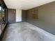 Enclosed porch with concrete flooring, and access door to backyard at 1819 E Humphrey St, Tampa, FL 33604