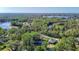 Stunning aerial view of a property nestled among lush trees, with a nearby lake offering beautiful natural surroundings at 21940 Dupree Dr, Land O Lakes, FL 34639