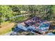 Aerial view of a charming home with a screened-in pool surrounded by mature trees, providing a private oasis at 21940 Dupree Dr, Land O Lakes, FL 34639