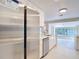 Bright kitchen with stainless steel refrigerator and white cabinets with a pass-through to a sunroom at 21940 Dupree Dr, Land O Lakes, FL 34639