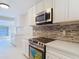 Well-lit kitchen with modern appliances, sleek cabinetry, and stylish backsplash detailing at 21940 Dupree Dr, Land O Lakes, FL 34639