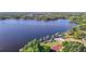Breathtaking aerial shot capturing the beauty of the lake with the tennis court and surrounding landscape at 21940 Dupree Dr, Land O Lakes, FL 34639