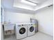 Bright laundry room featuring a utility sink and newer appliances at 21940 Dupree Dr, Land O Lakes, FL 34639