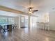 Bright, open-concept living room with a ceiling fan and stylish wood flooring at 21940 Dupree Dr, Land O Lakes, FL 34639