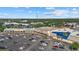 An aerial view of retail stores with parking lot and palm trees and green trees at 3772 Bath Ln, North Port, FL 34288