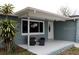 Welcoming front porch with a seating area and white framed window and door at 3841 Chaffey Dr, New Port Richey, FL 34652