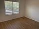 Well-lit bedroom with luxury vinyl flooring and a view of the outdoors at 11330 Godwit Ave, Weeki Wachee, FL 34613