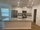 Modern kitchen features an island, stainless steel appliances, granite countertops, and white cabinets at 11330 Godwit Ave, Weeki Wachee, FL 34613