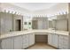 Bright bathroom featuring an expansive vanity with dual sinks, large mirrors, and ample storage space at 1171 Clays Trl, Oldsmar, FL 34677
