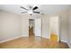 Bright bedroom with hardwood flooring, ceiling fan, and access to closet and other rooms at 1171 Clays Trl, Oldsmar, FL 34677