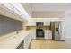 Well-lit kitchen featuring stainless steel appliances, white cabinets, and tiled floors at 1171 Clays Trl, Oldsmar, FL 34677