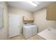 Laundry room featuring a side-by-side washer and dryer, utility sink, and storage cabinets at 1171 Clays Trl, Oldsmar, FL 34677