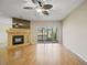 Bright living room featuring a ceiling fan, hardwood floors, a fireplace, and scenic views through sliding glass doors at 1171 Clays Trl, Oldsmar, FL 34677
