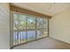 Enclosed porch with screened windows offering serene views of the lake and surrounding foliage at 1171 Clays Trl, Oldsmar, FL 34677
