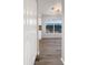 Bright hallway leading to the kitchen, featuring wood flooring, a window view, and natural light at 3403 30Th E Ln, Bradenton, FL 34208