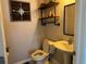 Cozy half-bathroom with industrial shelving and a pedestal sink at 3721 Heron Island Dr, New Port Richey, FL 34655