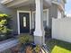 Inviting front porch with a black door, stylish plants, and decorative features at 3721 Heron Island Dr, New Port Richey, FL 34655