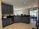 Modern kitchen featuring gray cabinets, granite countertops, and stainless steel appliances at 3721 Heron Island Dr, New Port Richey, FL 34655