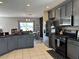 Stylish kitchen with gray cabinets, stainless steel appliances, and ample countertop space at 3721 Heron Island Dr, New Port Richey, FL 34655