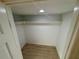 Walk-in closet with wood-look tile flooring, overhead lighting, and shelving for storage at 721 83Rd N Ave # 108, St Petersburg, FL 33702