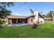 Exterior view of home with a screened-in patio and expansive lawn at 1117 Mook St, Brandon, FL 33510