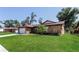 Exterior view of a charming house with a large grassy lawn, mature trees, and a stone facade at 1117 Mook St, Brandon, FL 33510
