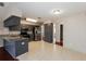 Modern kitchen with stainless steel appliances, gray cabinetry, granite countertops, and tile flooring at 1117 Mook St, Brandon, FL 33510