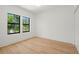 Clean bedroom with wood flooring, two windows, and white walls at 4115 N Central Ave, Tampa, FL 33603