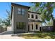 Two-story home with gray and white exterior, well-manicured lawn, and concrete driveway at 4115 N Central Ave, Tampa, FL 33603