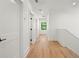 Well-lit hallway with hardwood floors, white walls, and multiple doorways at 4115 N Central Ave, Tampa, FL 33603