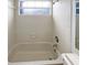 Bright bathroom featuring a tiled shower-tub combo and natural light at 6902 Lakeview Ct, Tampa, FL 33634