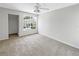 Neutral bedroom with carpeted floors, a ceiling fan, and a large window offering natural light at 6902 Lakeview Ct, Tampa, FL 33634