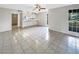 Open-concept living room and kitchen featuring neutral tile, natural light, and ceiling fan at 6902 Lakeview Ct, Tampa, FL 33634
