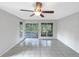 Bright, open living room featuring tiled flooring and glass doors leading to a screened patio at 6902 Lakeview Ct, Tampa, FL 33634