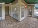 Covered patio with brick flooring, sliding glass doors, and a view of the surrounding landscape at 6902 Lakeview Ct, Tampa, FL 33634