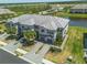 Beautiful aerial view of the gray townhomes, featuring lush landscaping and a tranquil pond in the background at 15242 Sunny Day Dr, Bradenton, FL 34211