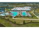 Aerial view showcasing the pool, clubhouse, and tennis courts within a well-maintained community at 15242 Sunny Day Dr, Bradenton, FL 34211