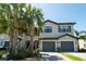 Charming two-story townhome with a two-car garage, complemented by well-maintained landscaping and palm trees at 15242 Sunny Day Dr, Bradenton, FL 34211