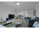 Spacious living area with a modern design, featuring a sleek television and access to the dining area at 15242 Sunny Day Dr, Bradenton, FL 34211