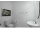 Clean powder room features a sleek pedestal sink, toilet, and wall art at 15242 Sunny Day Dr, Bradenton, FL 34211