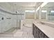 Luxurious primary bathroom with marble tile, glass shower, and soaking tub at 1966 Hyde Park St, Sarasota, FL 34239