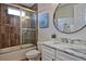 Well-lit bathroom with a shower, tub combo, white cabinets, and marble countertop sink at 1966 Hyde Park St, Sarasota, FL 34239