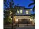 Exterior elevation of a two story stucco home with a tile roof, gate and lush landscaping at 1966 Hyde Park St, Sarasota, FL 34239