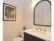 Contemporary powder room with modern fixtures, framed artwork, and stylish mirror at 1966 Hyde Park St, Sarasota, FL 34239