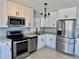 Modern kitchen featuring stainless steel appliances, white cabinets, and granite countertops at 3735 Alabama Ne Ave, St Petersburg, FL 33703