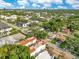 Expansive aerial view of multi-Gathering townhomes with red tile roofs, surrounded by lush greenery and street access at 4409 W Gray St # 5, Tampa, FL 33609