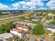 Aerial view showcasing multi-Gathering townhomes near lush greenery, adjacent highway, and distant city skyline at 4409 W Gray St # 5, Tampa, FL 33609