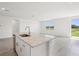 Granite kitchen island overlooks an airy living space and an outdoor pond at 7740 Gilchrist Springs Dr, Parrish, FL 34219